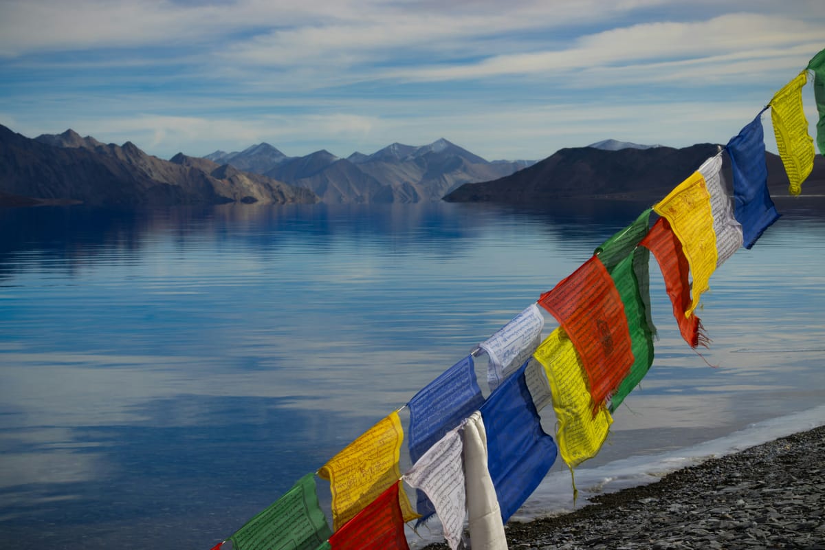 Colourful prayer flags at Pangong Tso shoreline, the 134 km lake straddles the India-China border and changes colour dramatically through the day