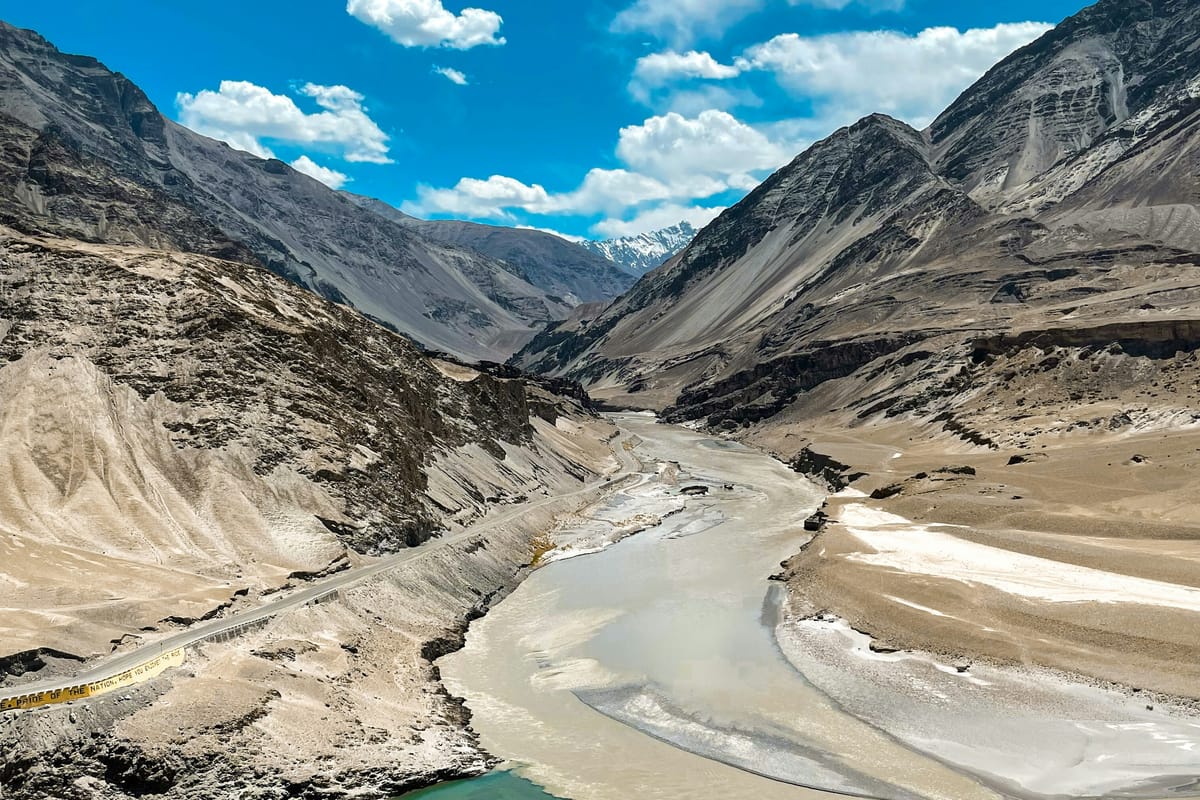 Aerial view of the Zanskar river meeting the Indus at Nimmu, the dramatic turquoise-meets-brown confluence makes this one of India's most scenic rafting stretches